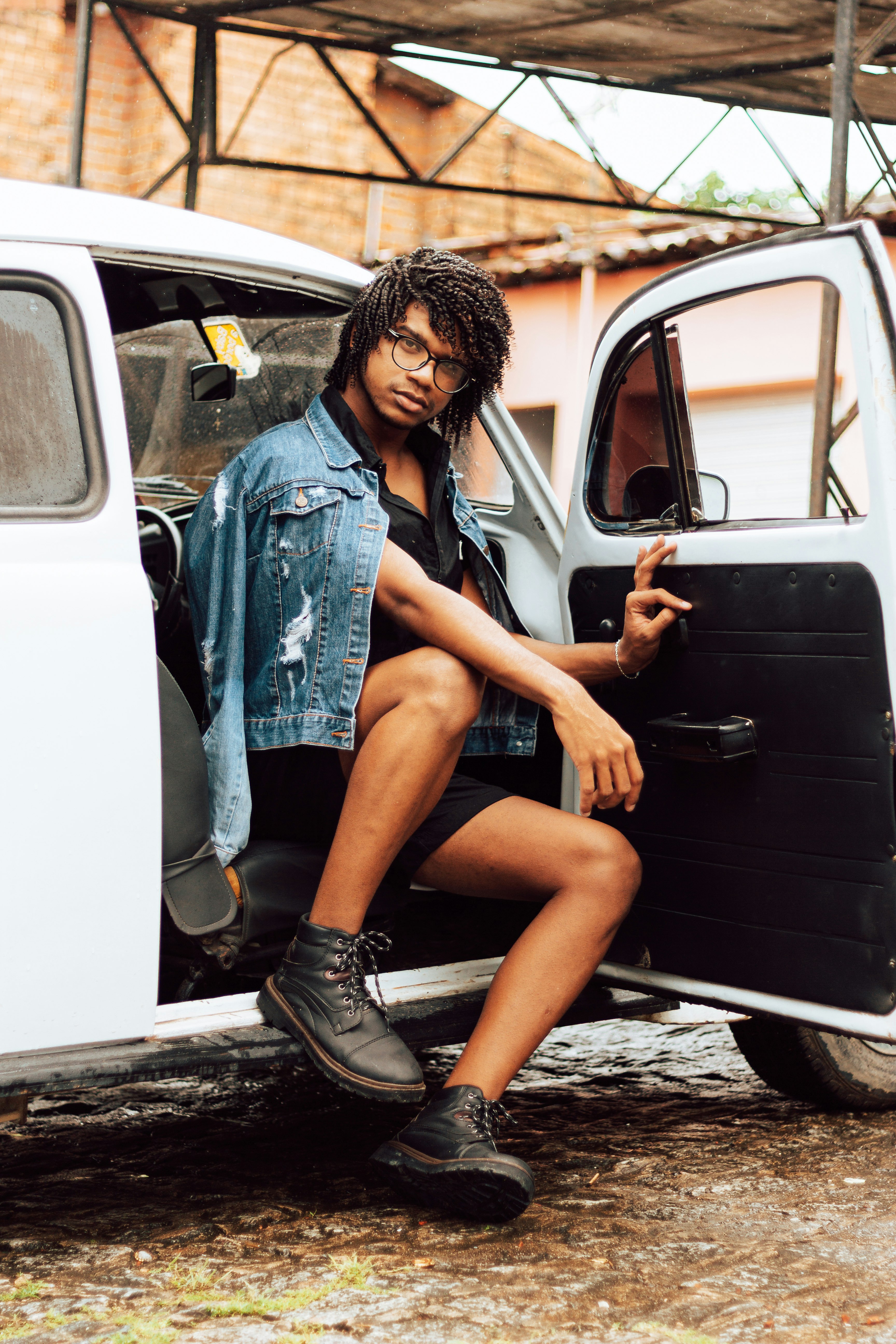 woman in blue denim jacket sitting on white car